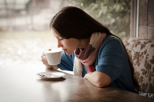 Beautiful young woman with a cup of tea at a cafe — Stock Photo, Image