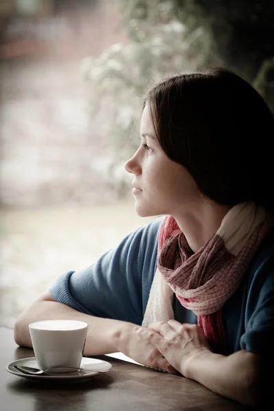 Beautiful young woman with a cup of tea at a cafe — Stock Photo, Image