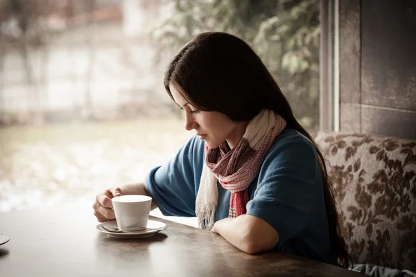 Красива молода жінка з чашкою чаю в кафе — стокове фото