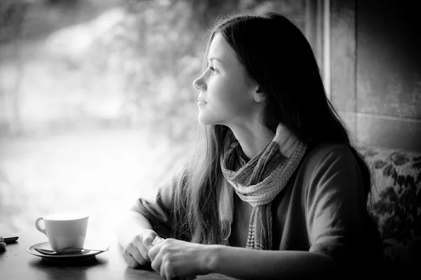 Beautiful young woman with a cup of tea at a cafe — Stock Photo, Image