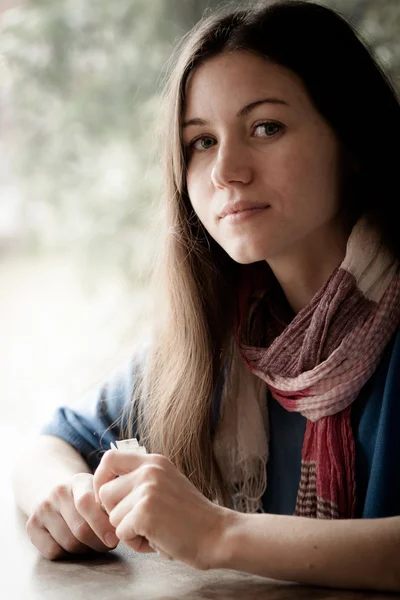 Schöne junge Frau mit einer Tasse Tee in einem Café — Stockfoto