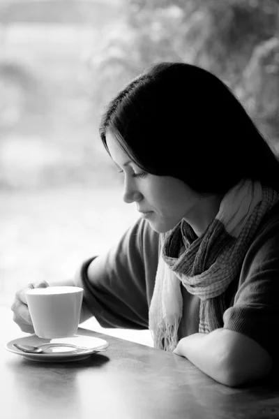 Gyönyörű fiatal nő egy csésze teával egy kávézóban. — Stock Fotó