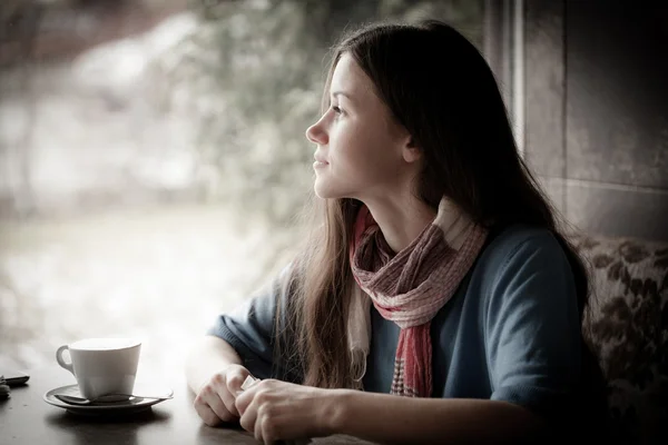 Beautiful young woman with a cup of tea at a cafe — Stock Photo, Image