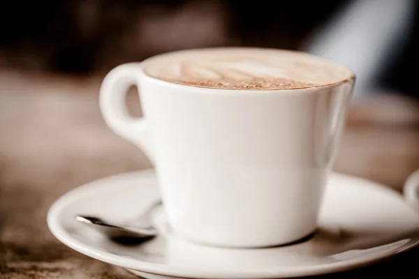 Tasse Cappuccino über Holztisch — Stockfoto