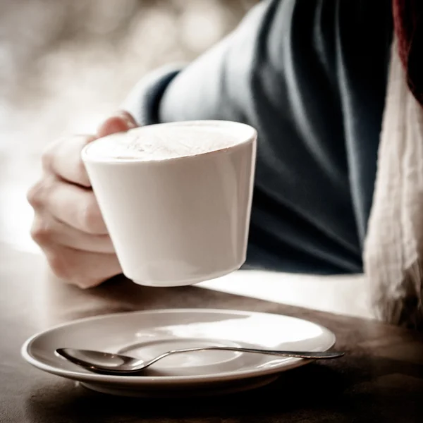 Woman hands with latte on a wood table — Stock Photo, Image