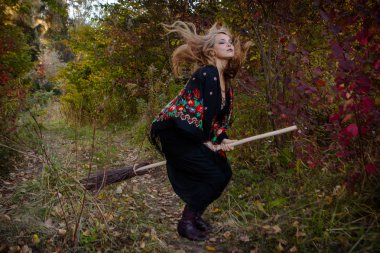 Genç kız bir sonbaharda Halloween cadı giyinmiş.