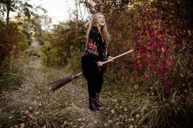 Genç kız bir sonbaharda Halloween cadı giyinmiş.