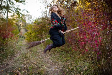 Genç kız bir sonbaharda Halloween cadı giyinmiş.