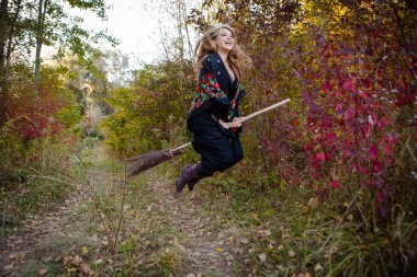 Genç kız bir sonbaharda Halloween cadı giyinmiş.