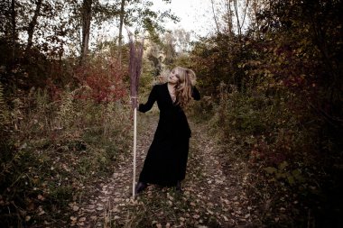 Genç kız bir sonbaharda Halloween cadı giyinmiş.