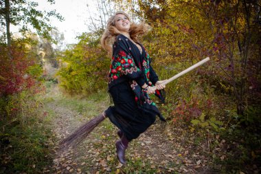 Genç kız bir sonbaharda Halloween cadı giyinmiş.