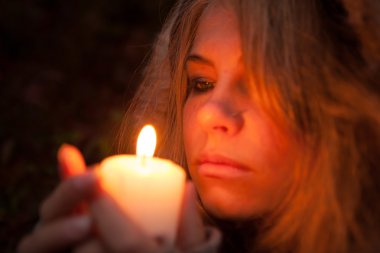 bir mum arayan genç bir kadın