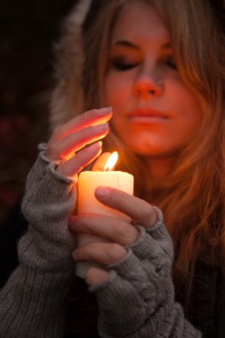 bir mum arayan genç bir kadın