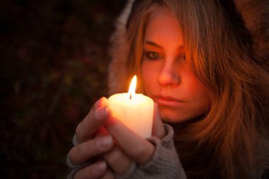 bir mum arayan genç bir kadın