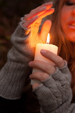 bir mum arayan genç bir kadın