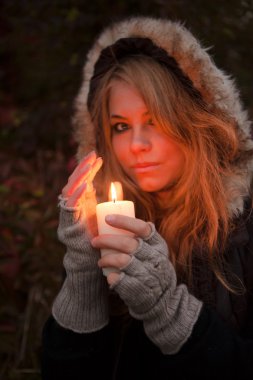 bir mum arayan genç bir kadın