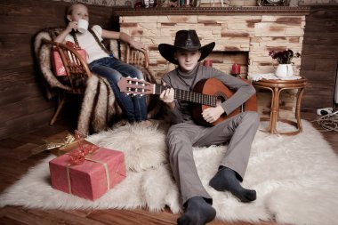 Yakışıklı mutlu çocuk akustik gitar çalmaya