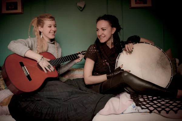 Две красивые женщины с бубном и гитарой — стоковое фото