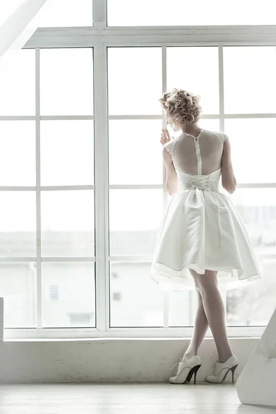 The bride standing on the window — Stock Photo, Image