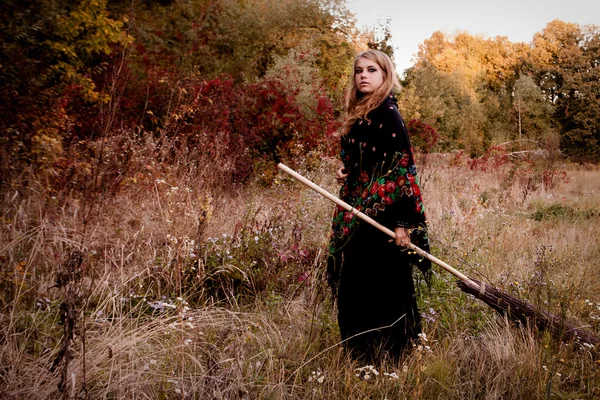 Oung menina vestida em uma queda bruxa de Halloween — Fotografia de Stock