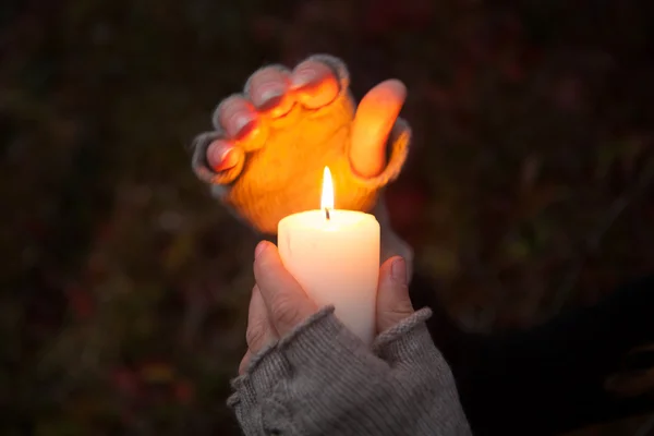 Bedjande händer med ljus i mörk bakgrund — Stockfoto