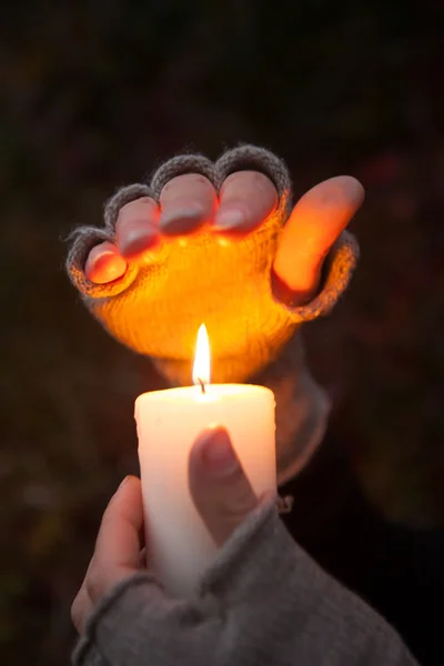 Young woman looking to a candle Praying Hands with candle in dark background — Stock Photo, Image