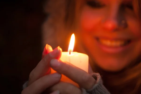 Jonge vrouw op zoek naar een kaars — Stockfoto