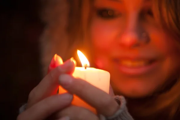 Mujer joven mirando a una vela — Foto de Stock