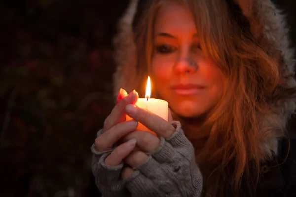 Young woman looking to a candle — Stock Photo, Image