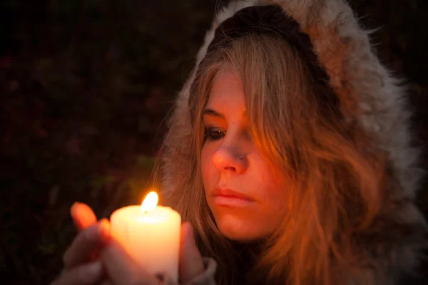 Young woman looking to a candle — Stock Photo, Image