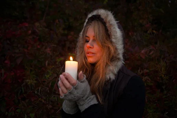 Young woman looking to a candle — Stock Photo, Image