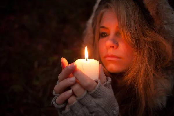 Mujer joven mirando a una vela — Foto de Stock