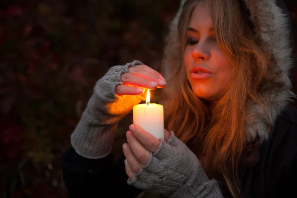 Giovane donna in cerca di una candela — Foto Stock