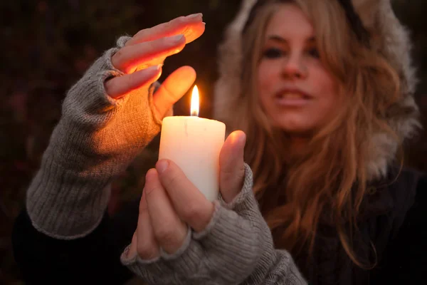 Mujer joven mirando a una vela — Foto de Stock