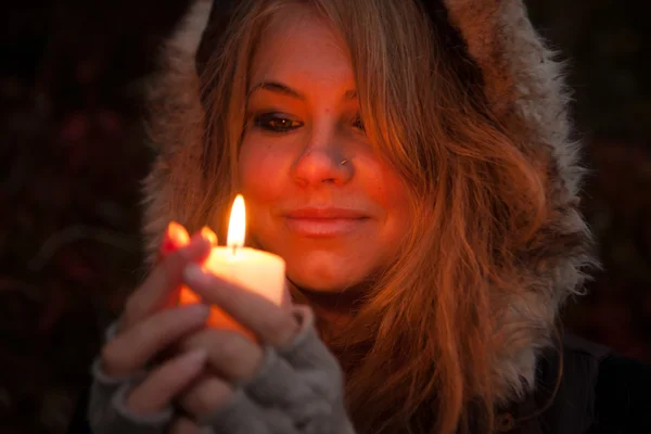 Giovane donna in cerca di una candela — Foto Stock