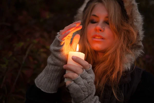 Jonge vrouw op zoek naar een kaars — Stockfoto