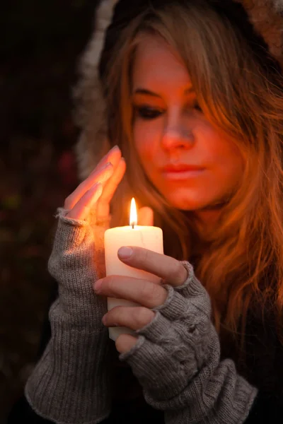 Young woman looking to a candle — Stock Photo, Image