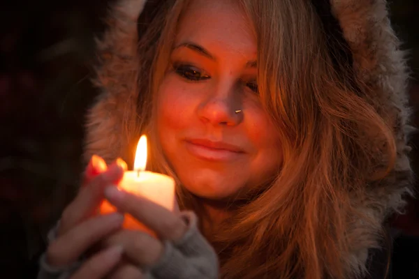 Молодая женщина смотрит на свечу — стоковое фото