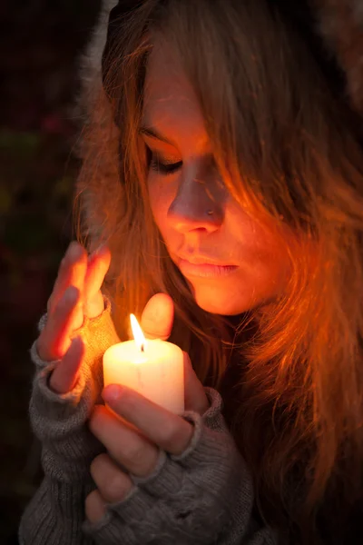 Jonge vrouw op zoek naar een kaars — Stockfoto