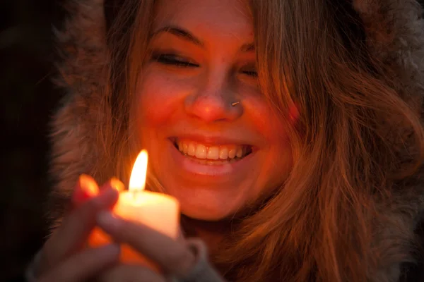 Young woman looking to a candle — Stock Photo, Image