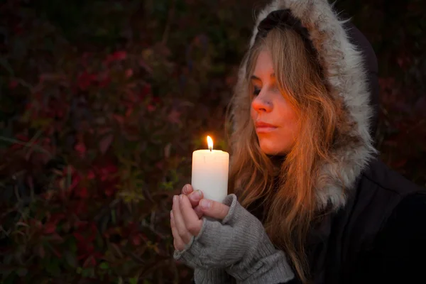 Mujer joven mirando a una vela — Foto de Stock