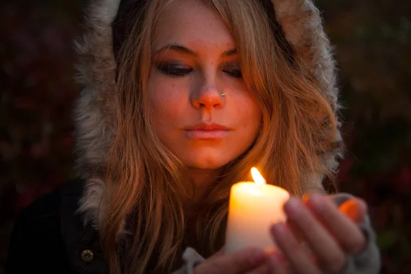 Mujer joven mirando a una vela — Foto de Stock