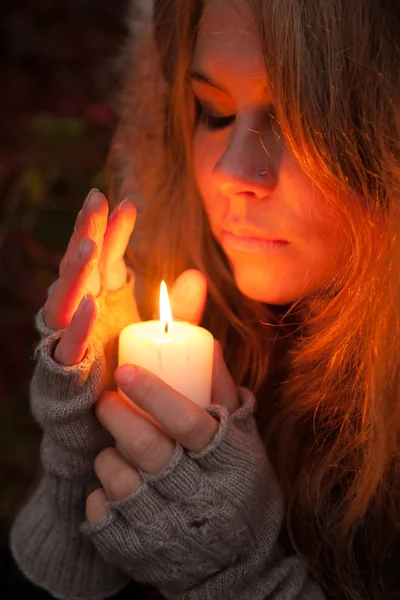 Mujer joven mirando a una vela — Foto de Stock