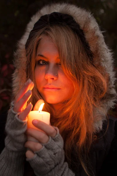 Junge Frau blickt auf eine Kerze — Stockfoto