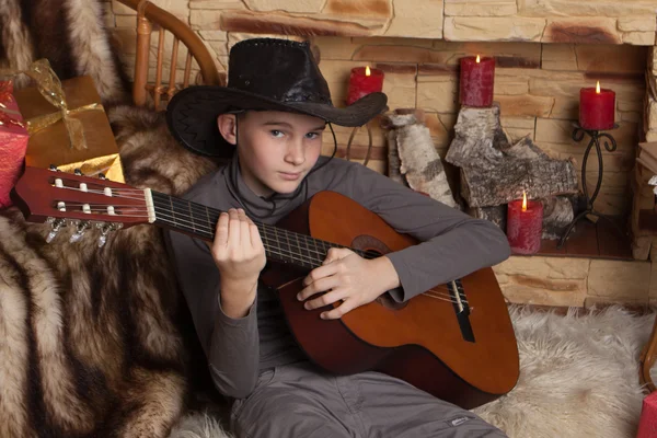 Knappe gelukkige jongen speelt op akoestische gitaar — Stockfoto