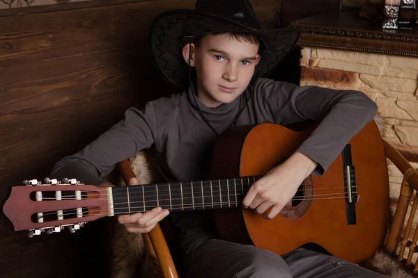 Knappe gelukkige jongen speelt op akoestische gitaar — Stockfoto