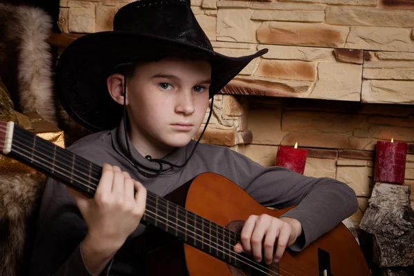 Knappe gelukkige jongen speelt op akoestische gitaar — Stockfoto