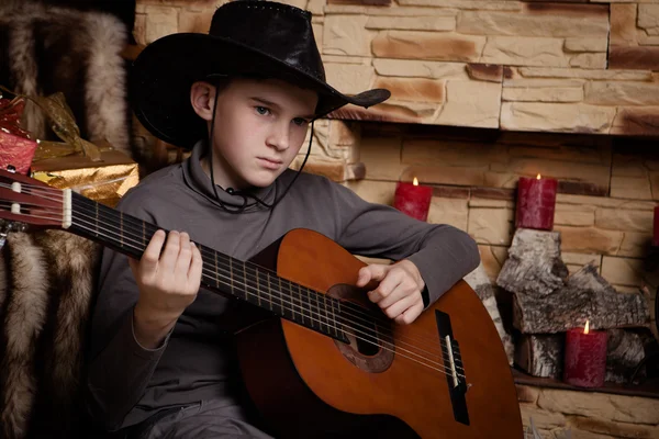Knappe gelukkige jongen speelt op akoestische gitaar — Stockfoto