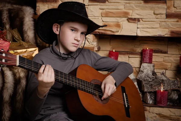 Knappe gelukkige jongen speelt op akoestische gitaar — Stockfoto