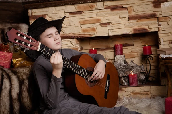 Handsome happy boy is playing on acoustic guitar — Stock Photo, Image